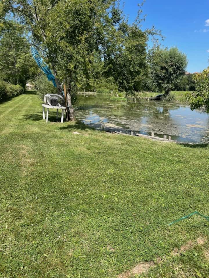 Etang privatif du domaine entoure de verdure en ete
