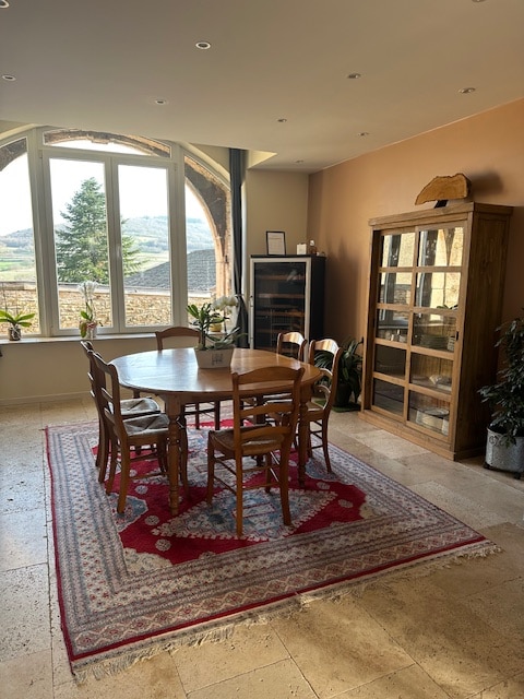 Salle a manger avec table conviviale vue sur vignoble et cave a vin